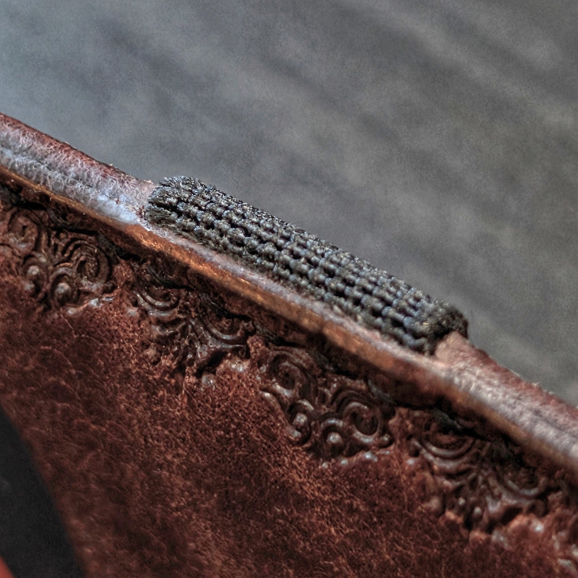 A tight closeup highlighting the ruggedly sleek profile and glass-slick, hand-burnished edges of The Melee in Tobacco.