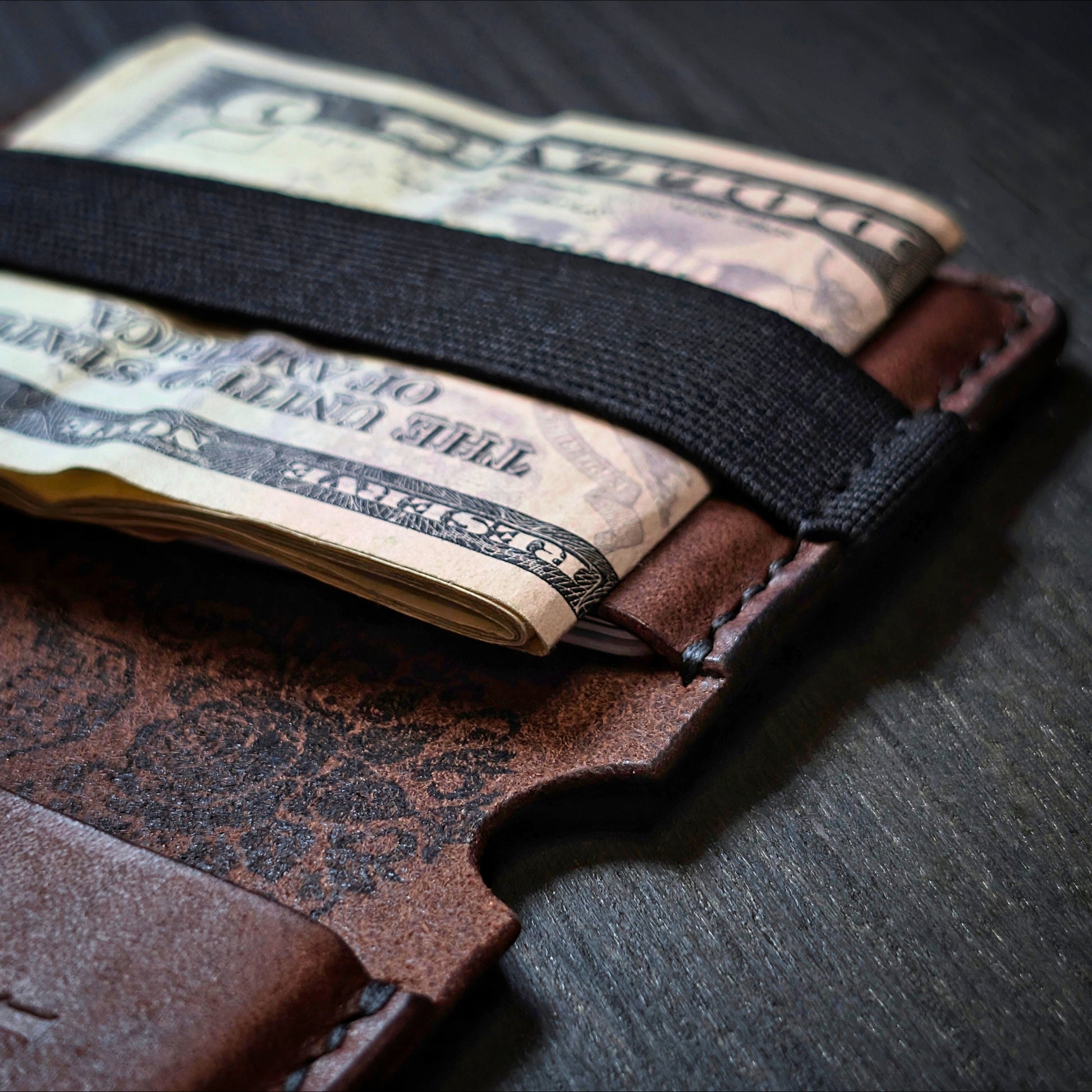 Close shot of the authentic El Rey Leather elastic woven cash strap on the Tobacco Scoundrel bifold wallet.