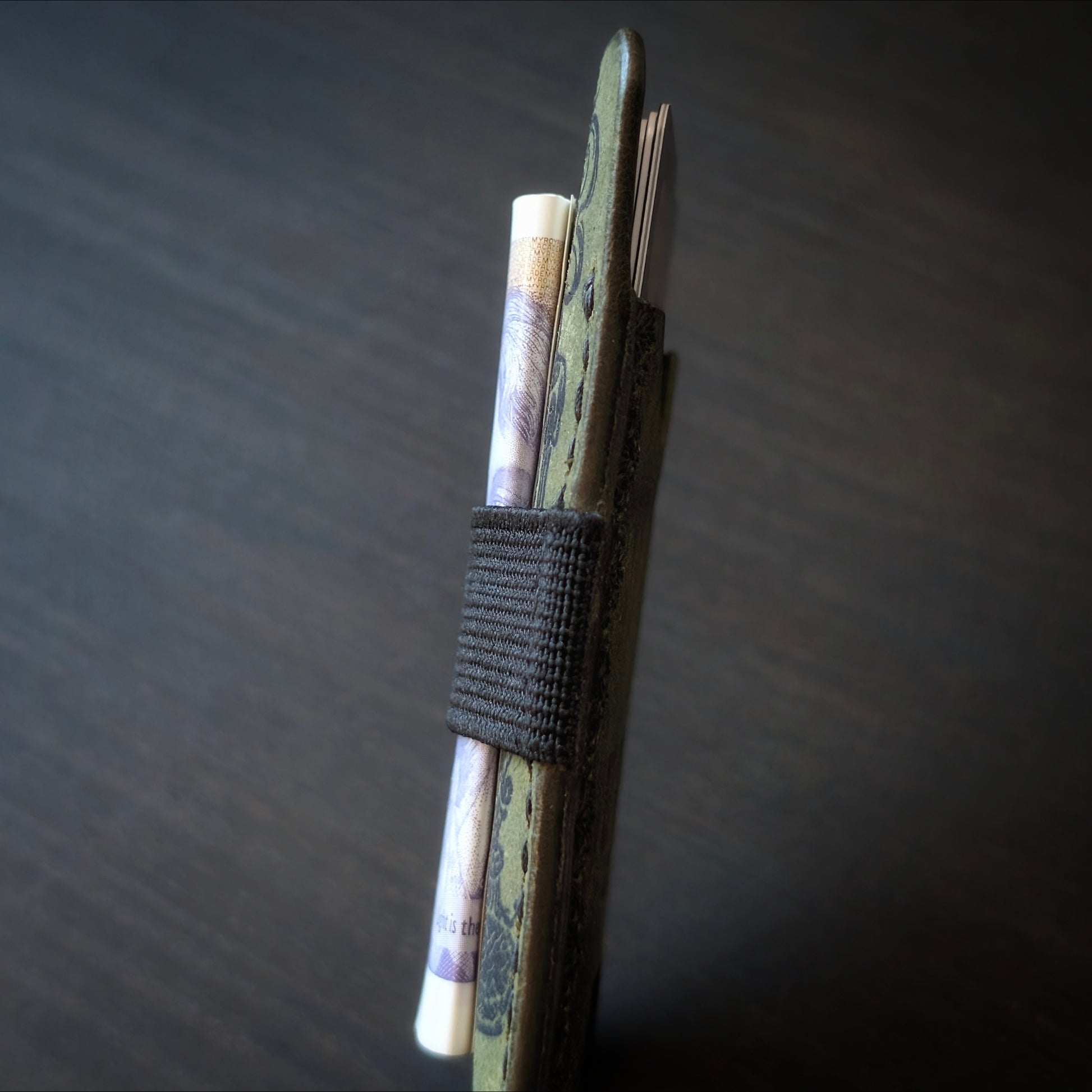 A tight closeup highlighting the ruggedly sleek profile and glass-slick, hand-burnished edges of The Melee in Olive.