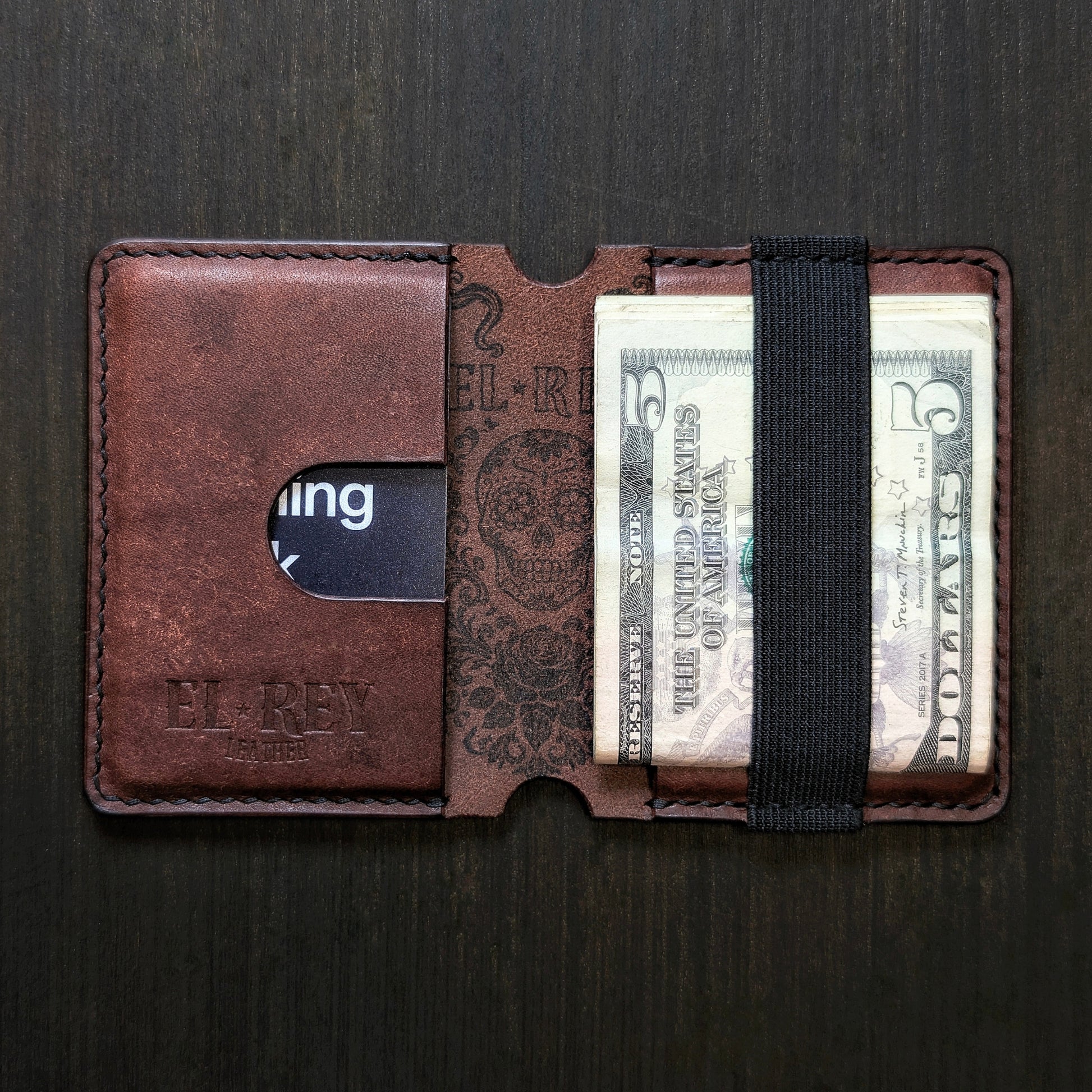Flat lay view of The Scoundrel slim cash and card organizer in premium Tobacco leather.