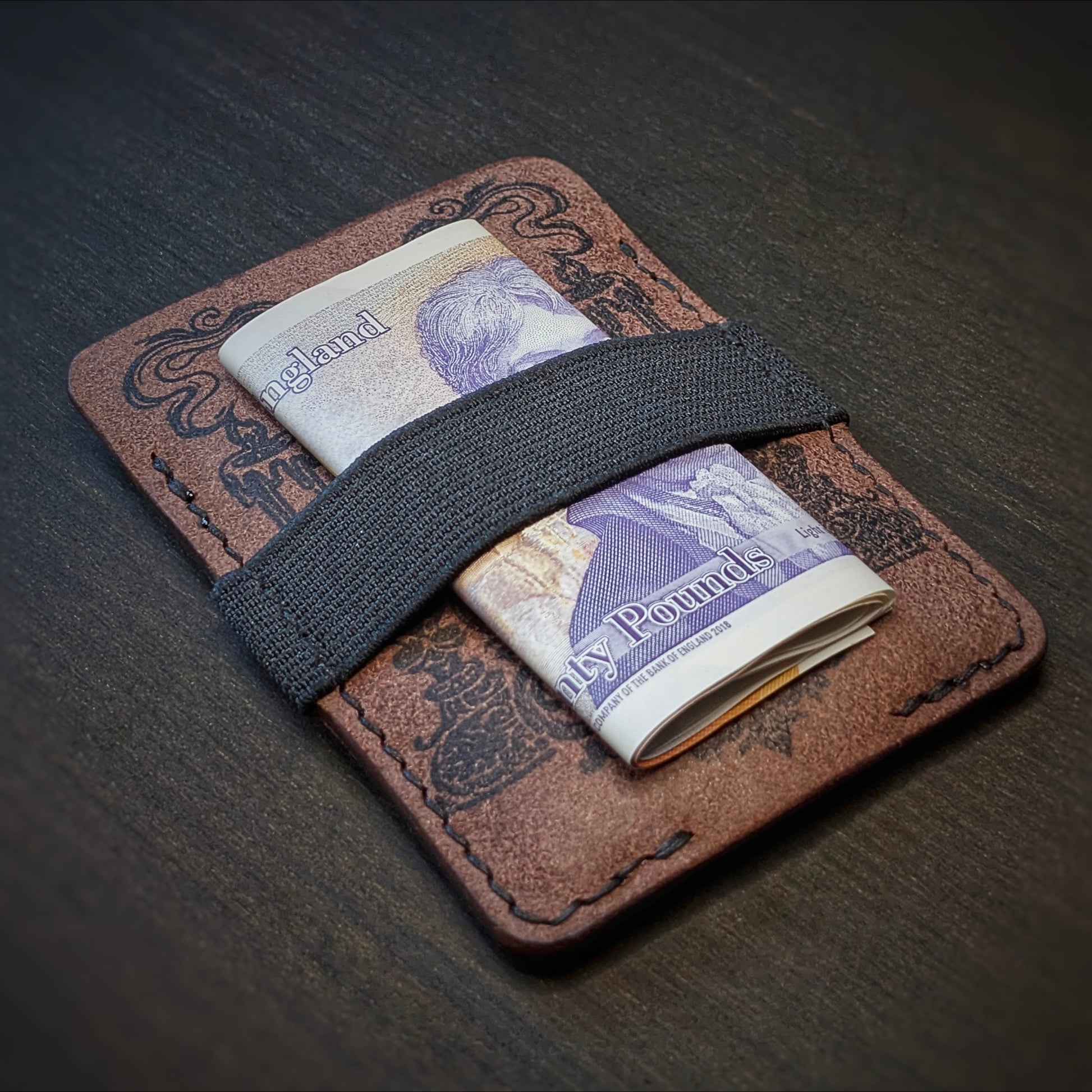 Tobacco Melee EDC wallet by El Rey Leather holding a folded UK banknote under a black elastic strap.