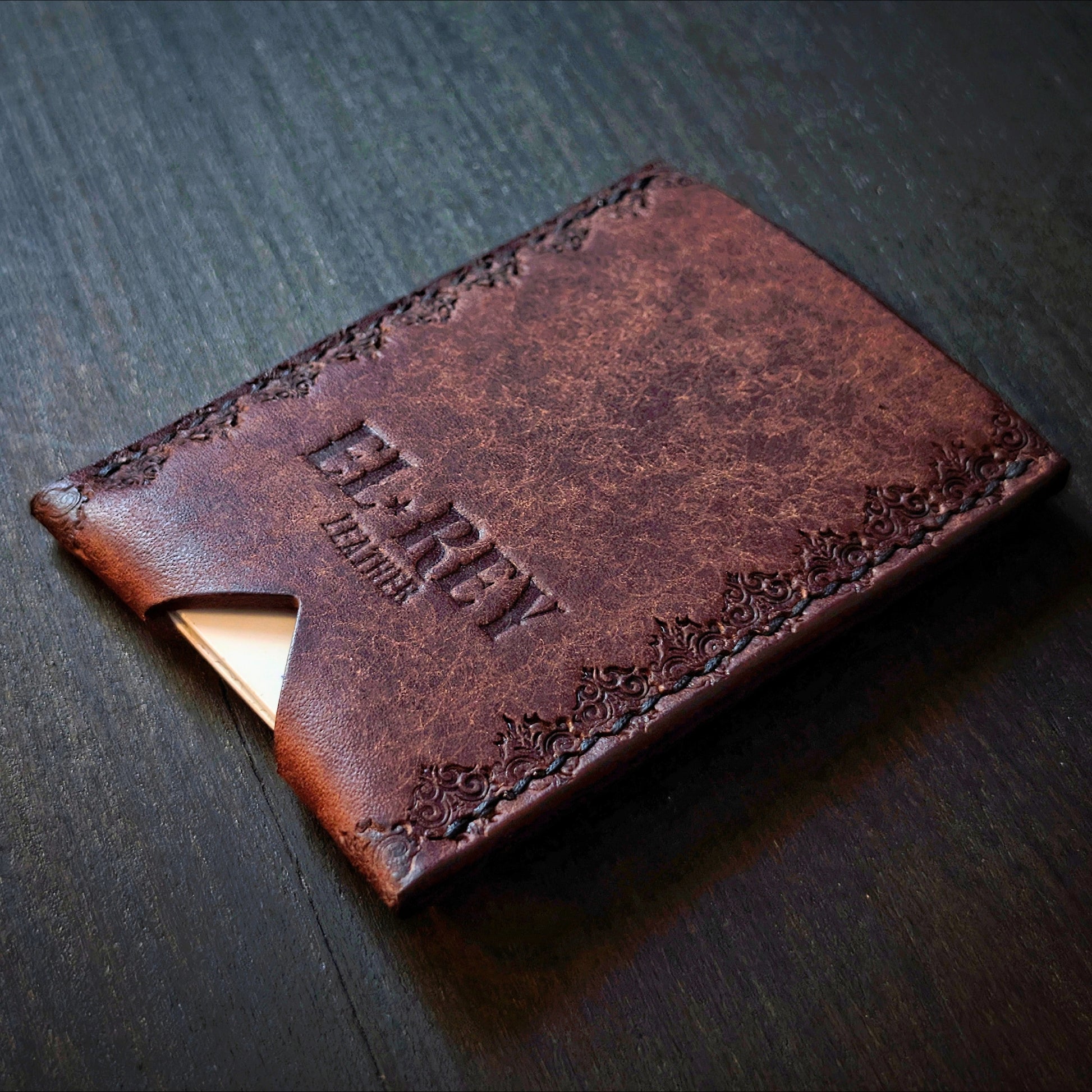 Rear angled view of El Rey Leather's Deadbeat minimalist wallet in tobacco with cards, showing the hand-stamped border.