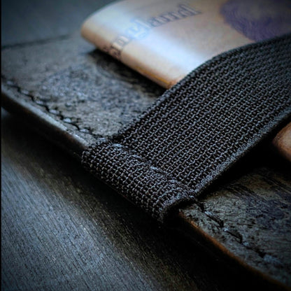 Close shot of the authentic El Rey Leather elastic woven cash strap on the Black Melee wallet.