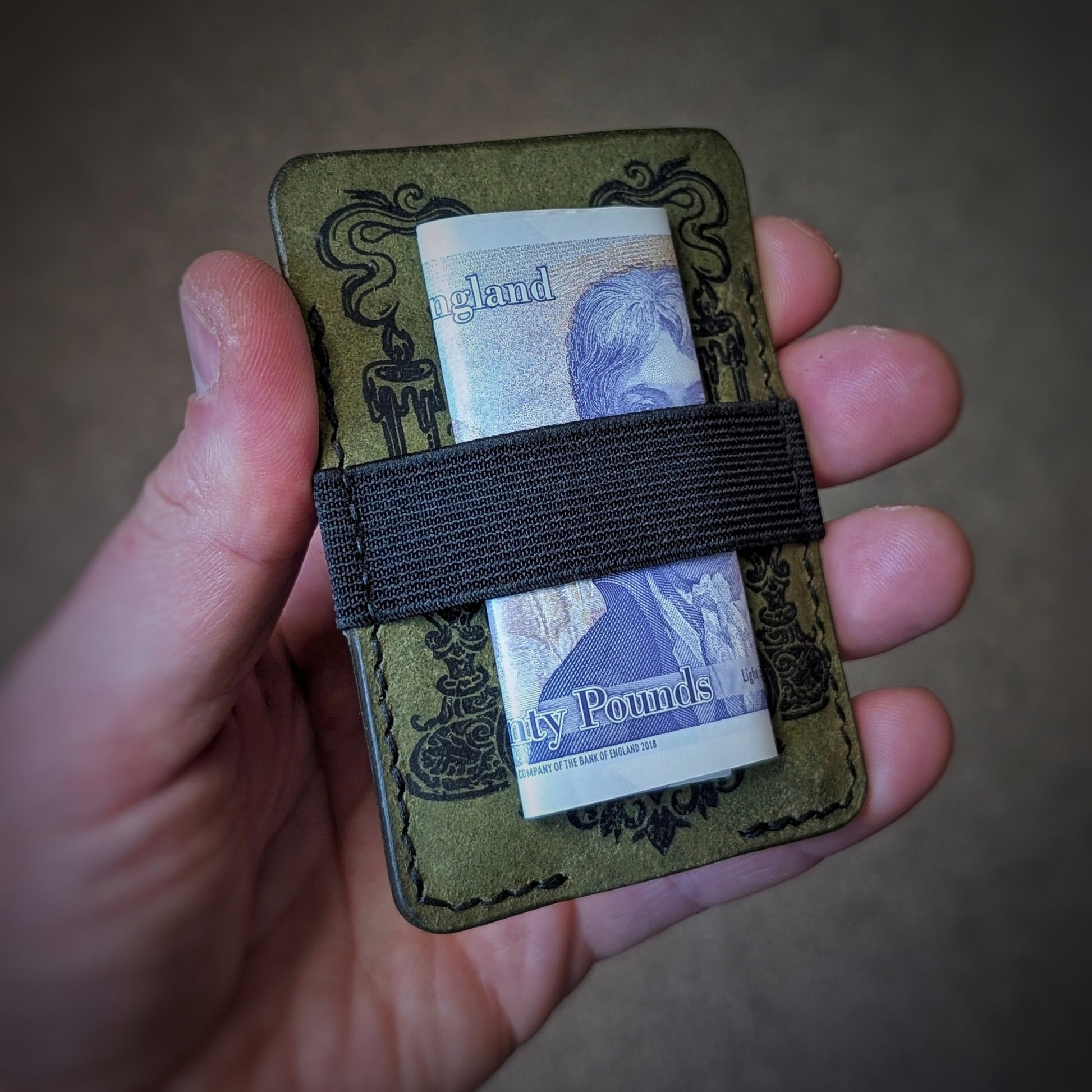 An open hand holding the El Rey Leather Melee minimalist wallet in Olive to demonstrate its slim size.