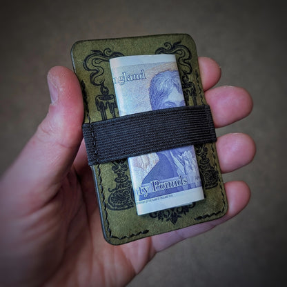 An open hand holding the El Rey Leather Melee minimalist wallet in Olive to demonstrate its slim size.