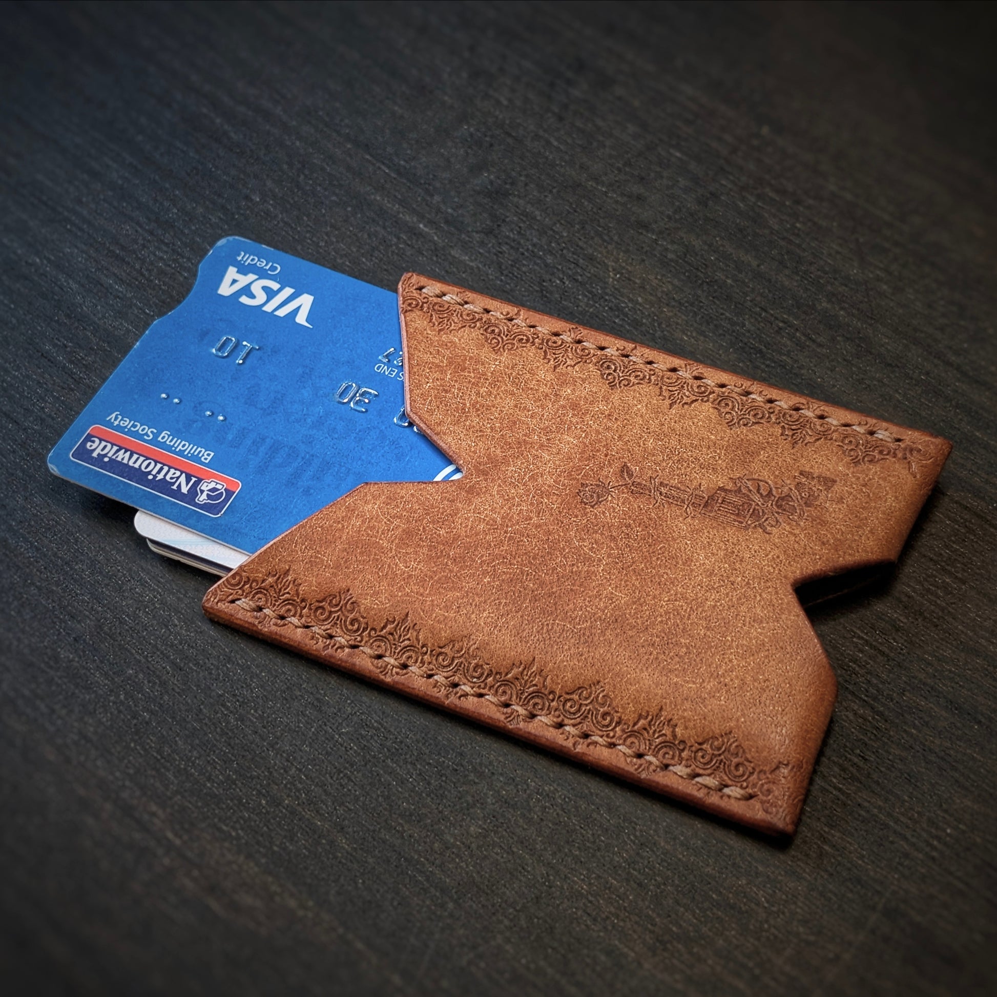 El Rey Leather Deadbeat minimalist leather wallet in cognac holding bank cards with detailed hand-stamping.