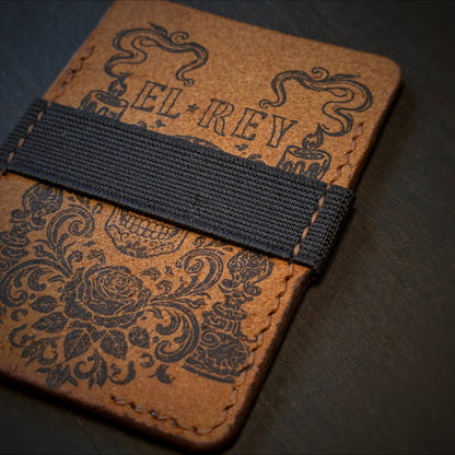 Close shot of the authentic El Rey Leather elastic cash strap and ink design on the Cognac Melee wallet.