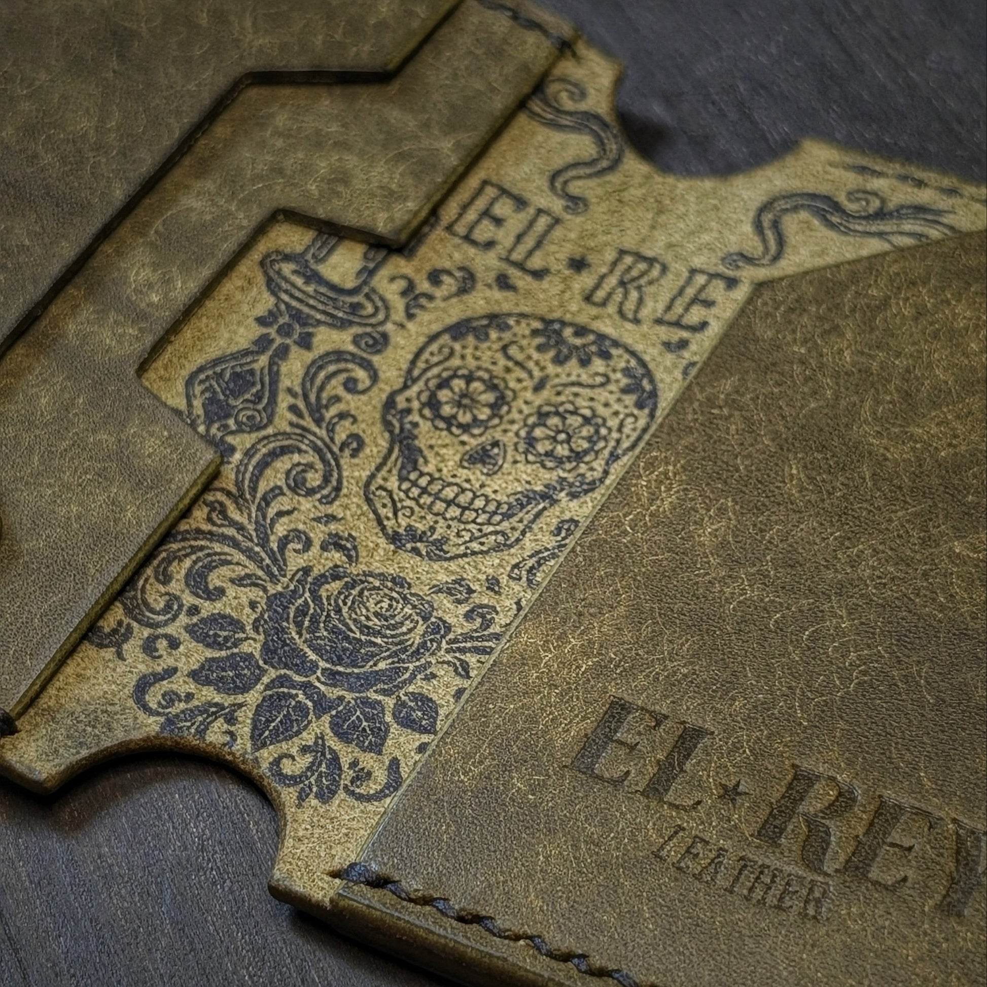 El Rey Leather Lowlife in olive leather, featuring an inked sugar skull design and minimalist card slots.