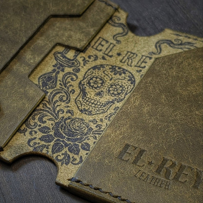 El Rey Leather Lowlife in olive leather, featuring an inked sugar skull design and minimalist card slots.
