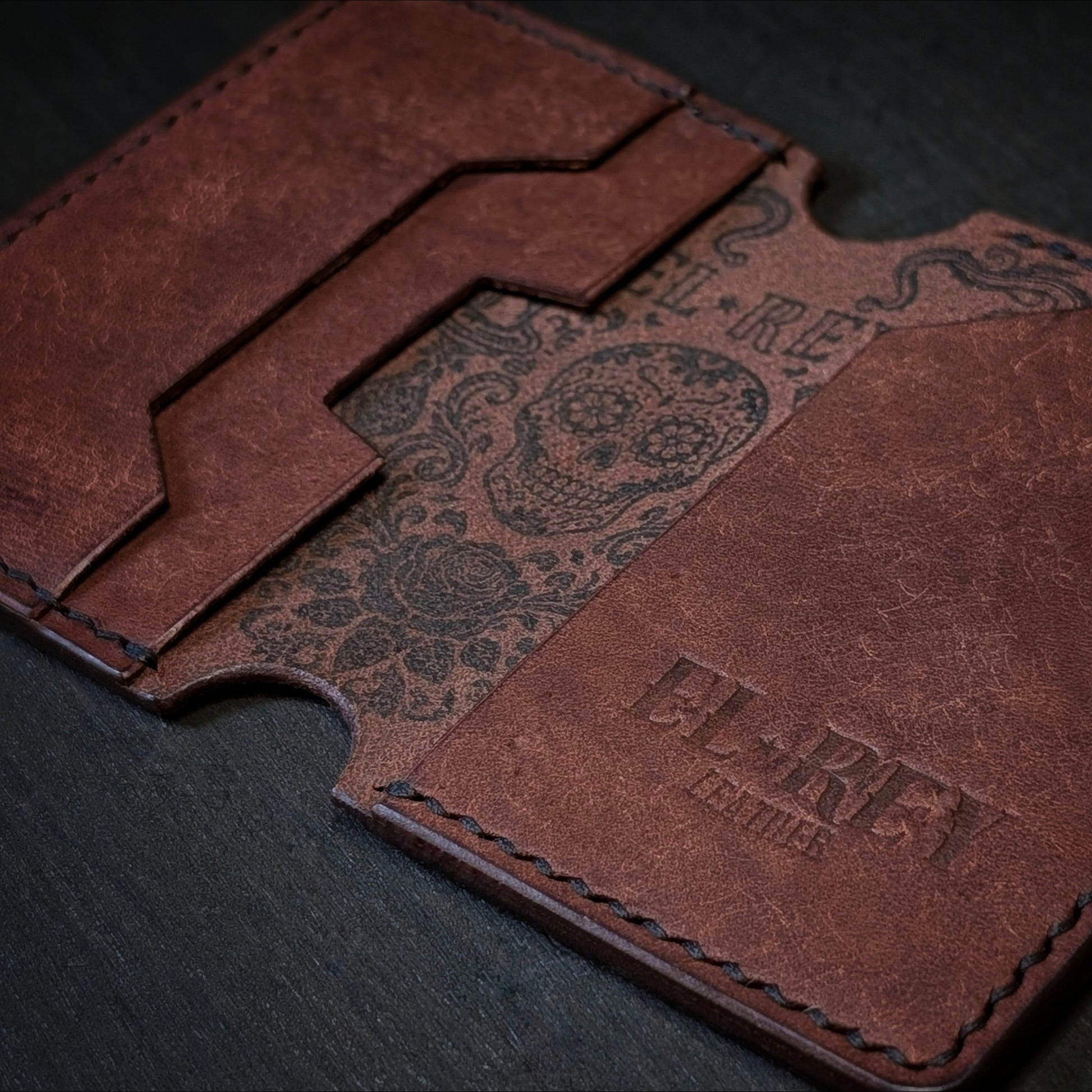 El Rey Leather Lowlife in tobacco leather, featuring an inked sugar skull design and minimalist card slots.
