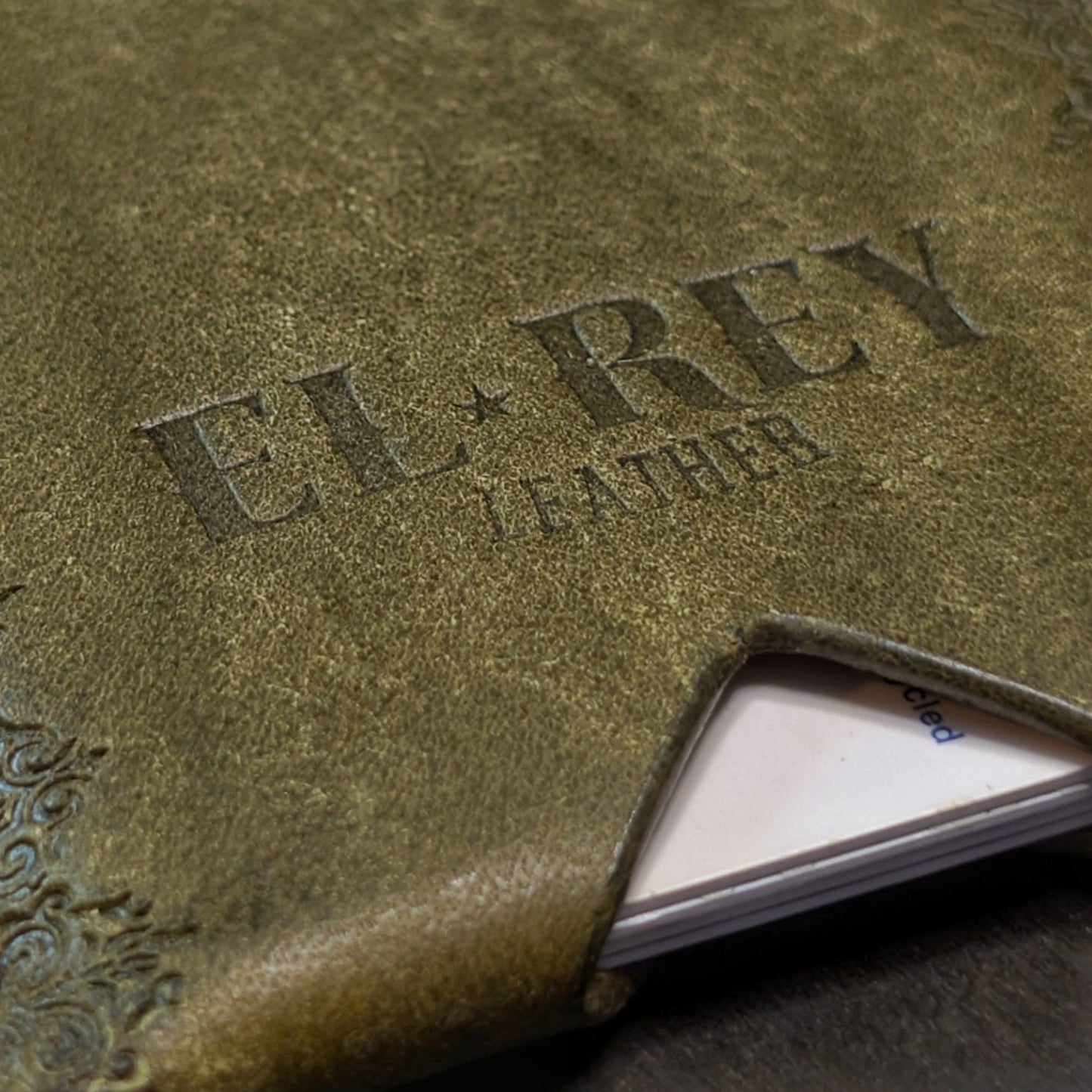 Macro texture shot of high-end olive leather on the handcrafted Deadbeat everyday carry wallet.