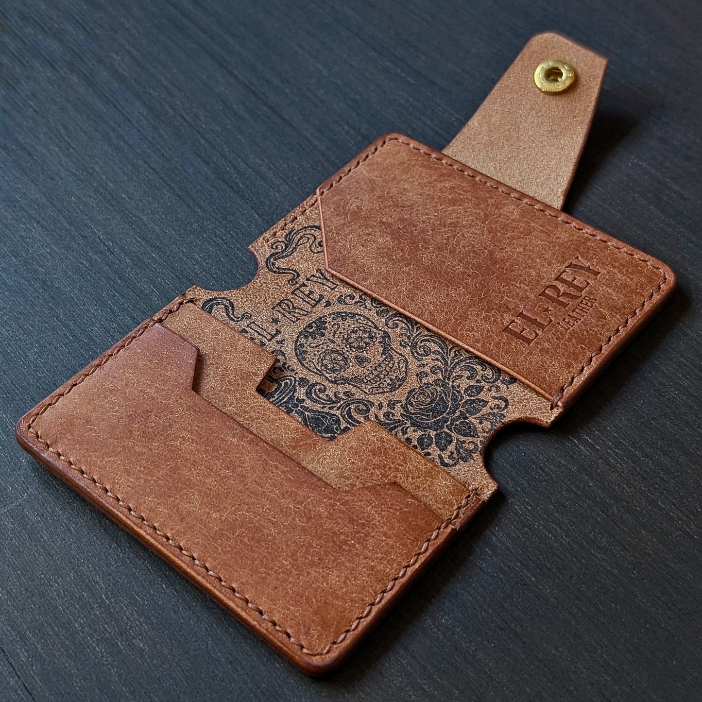 Flat lay view of The Lowlife slim cash and card organizer in premium cognac leather.