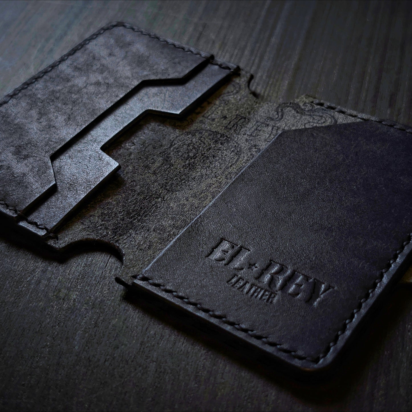 Flat lay view of The Lowlife slim cash and card organizer in premium black leather.