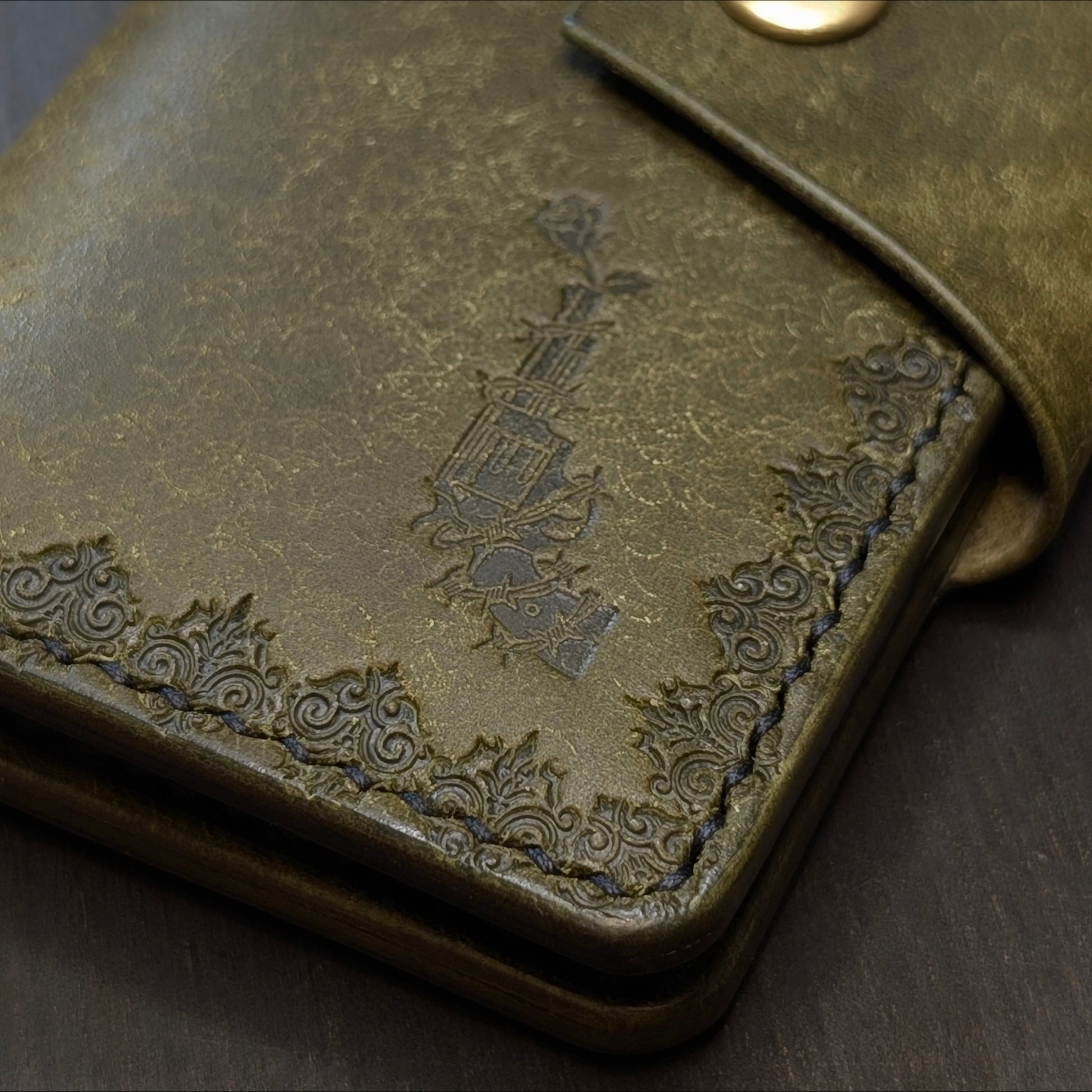 Close shot of the authentic El Rey Leather embossed maker's mark on the olive Lowlife card holder wallet.