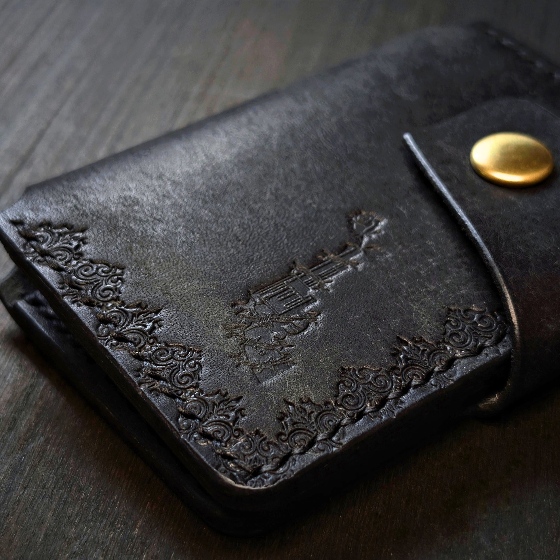 Close shot of the authentic El Rey Leather embossed maker's mark on the black Lowlife card holder wallet.