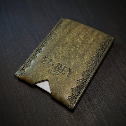 Rear angled view of El Rey Leather's Deadbeat minimalist wallet in olive with cards, showing the hand-stamped border.