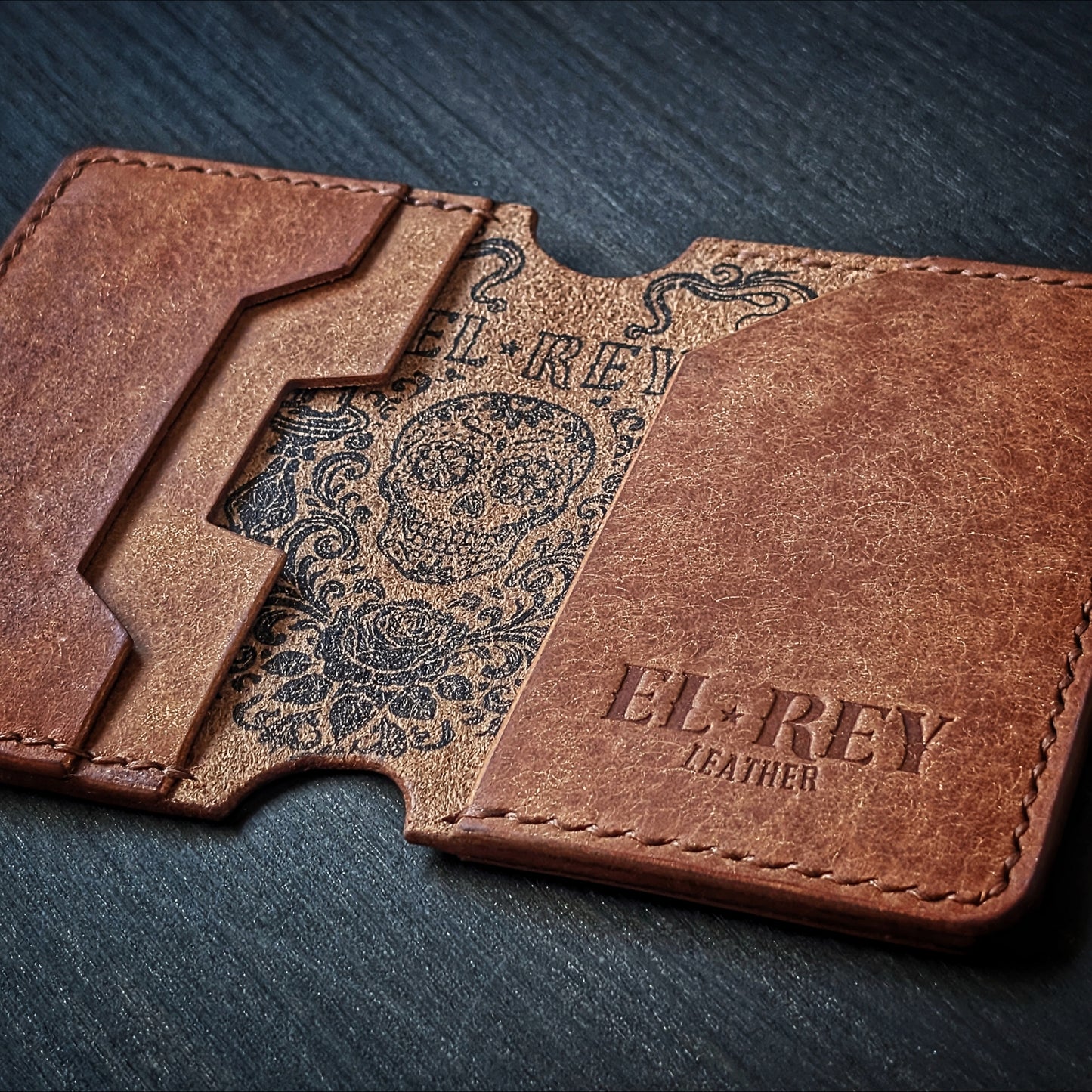 El Rey Leather Lowlife in cognac leather, featuring an inked sugar skull design and minimalist card slots.