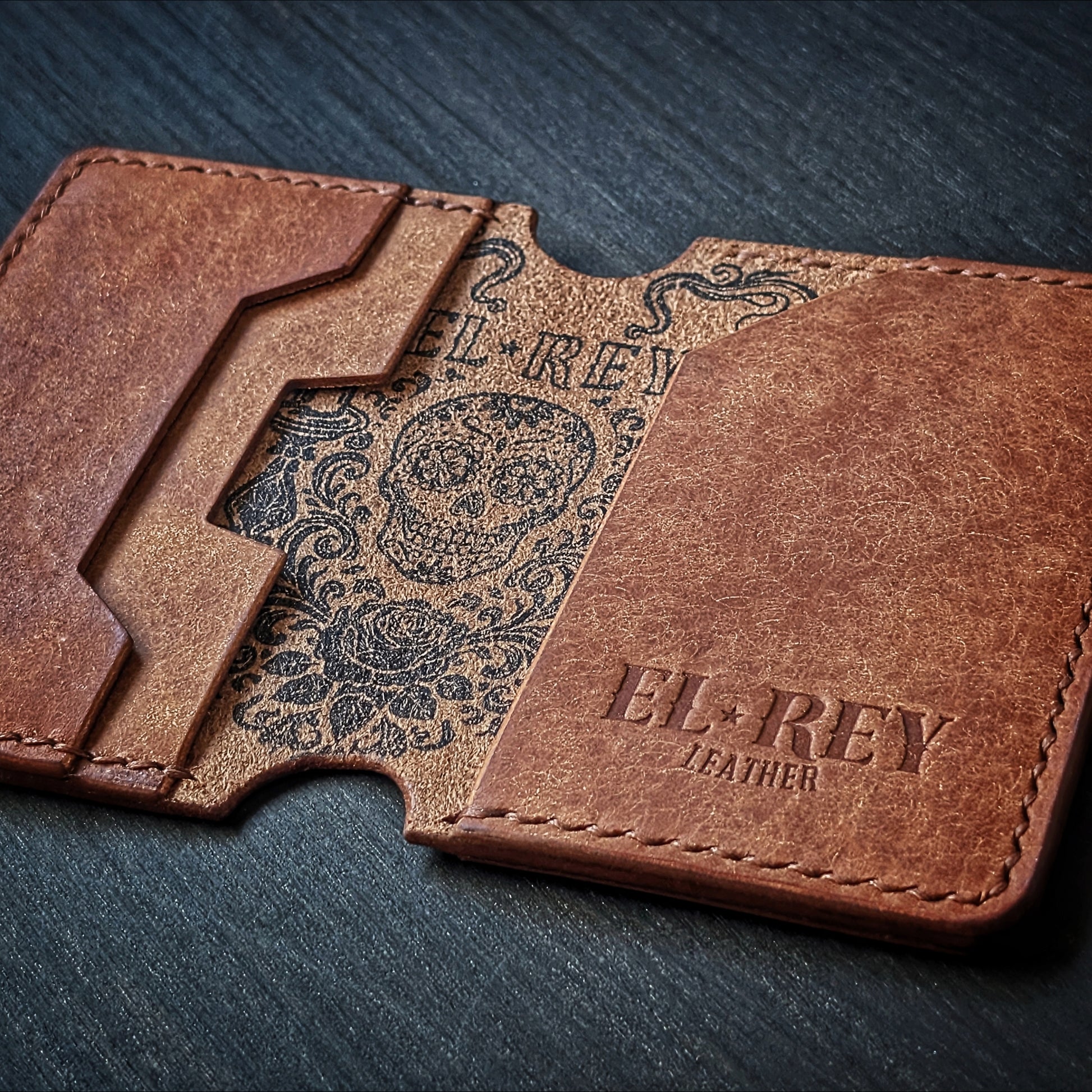 El Rey Leather Lowlife in cognac leather, featuring an inked sugar skull design and minimalist card slots.