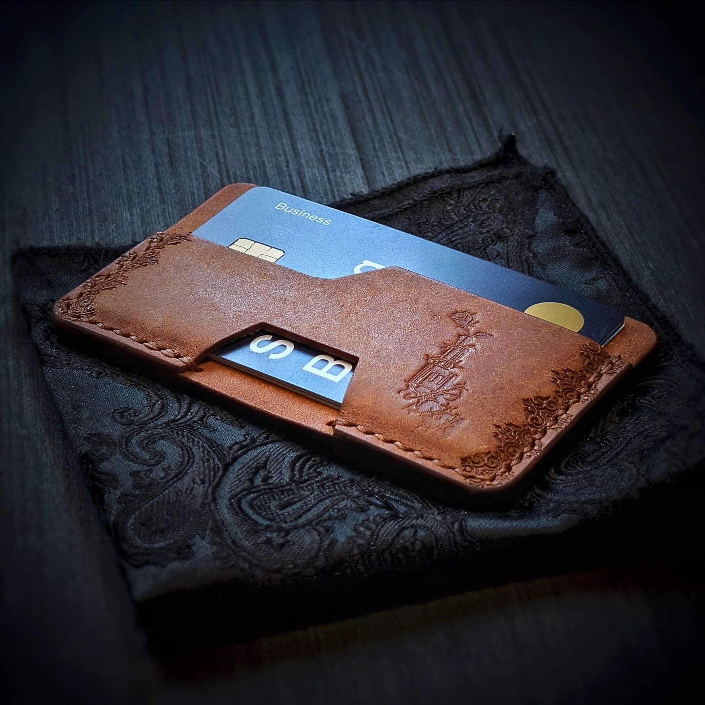 Angled view of El Rey's The Shiv minimalist wallet in Cognac holding cards, showing the hand-stamped border.