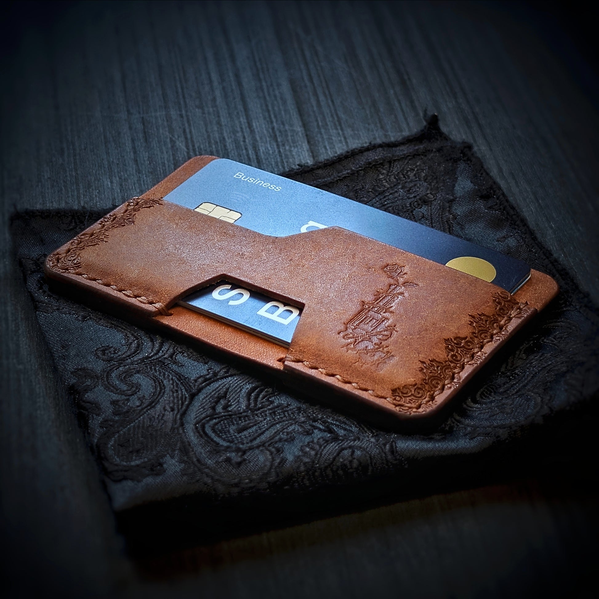Angled view of El Rey's The Shiv minimalist wallet in Cognac holding cards, showing the hand-stamped border.