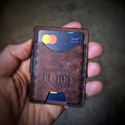 An open hand holding the El Rey Leather Melee minimalist wallet in Tobacco to demonstrate its slim size.